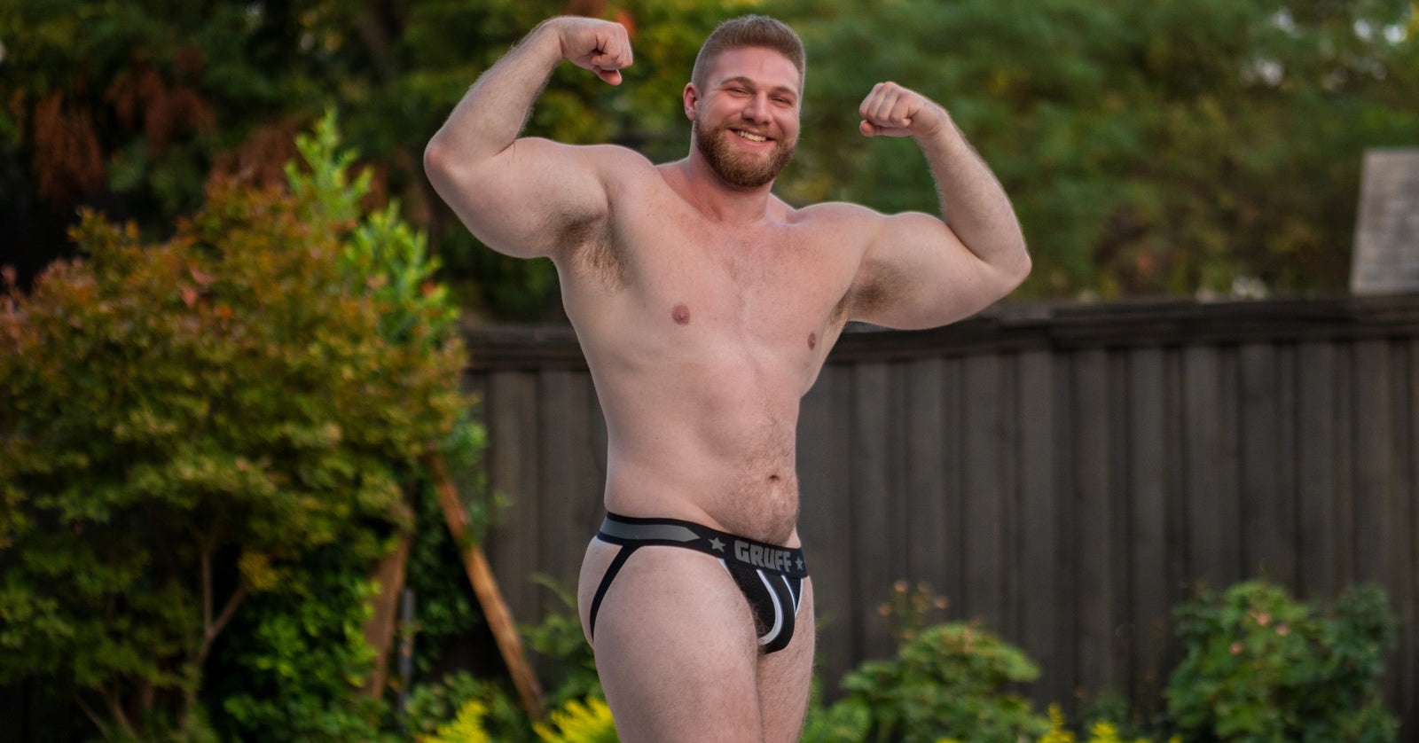 a masculine gay jock in a mens sexy jockstrap. This is a black jockstrap with a white jock stripe down the center of the pouch.