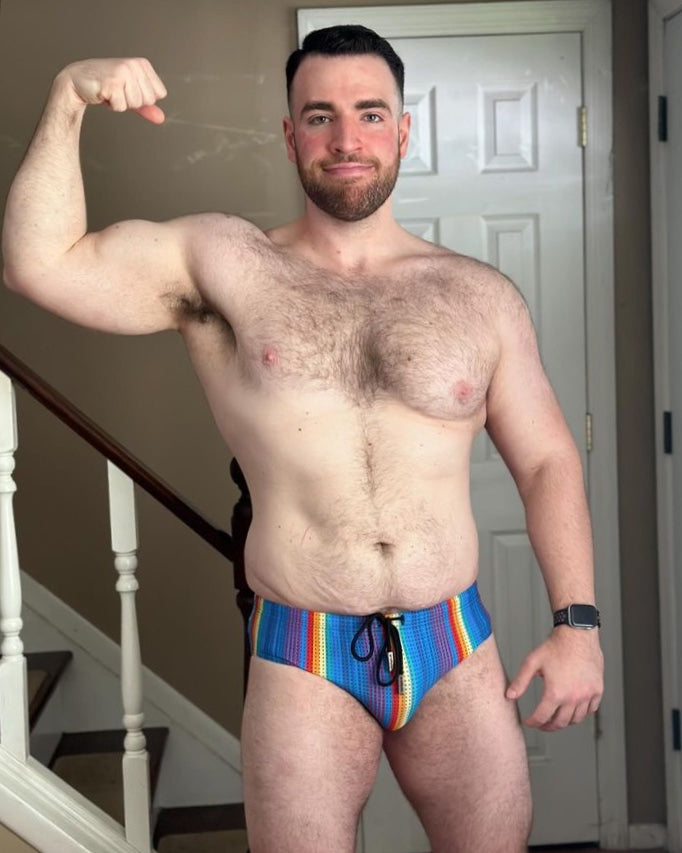 Ryan wearing Bulge Boost Swim Brief - Rainbow Ripple by Gruff Pup