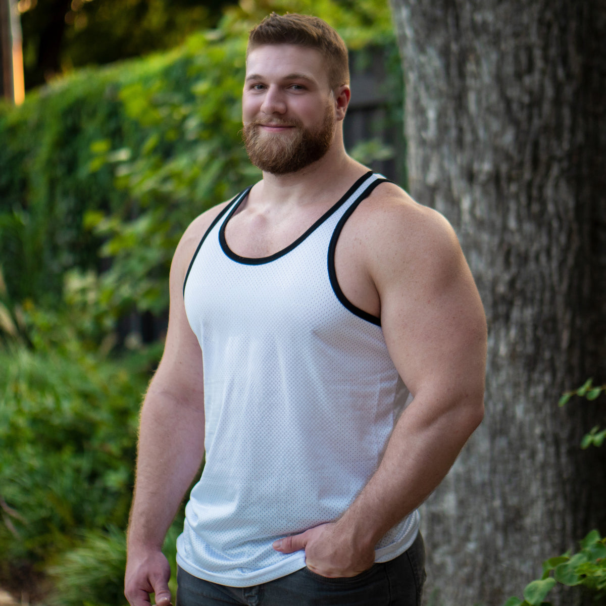 Handsome gay bear cub in a white tank top from Gruff Pup