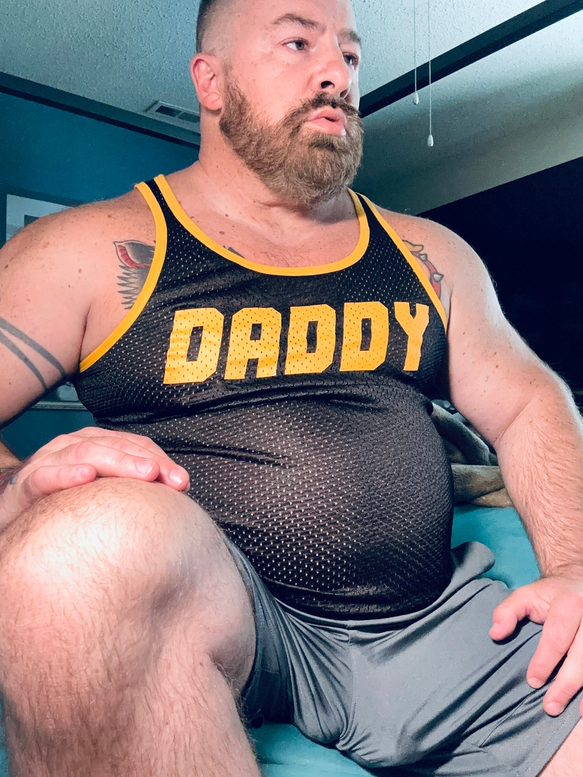 Customer wearing a black Gruff Pup Daddy Air Tank at home