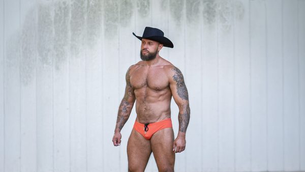 Model Stuart wearing a coral Gruff Pup Bulge Boost Swim Brief